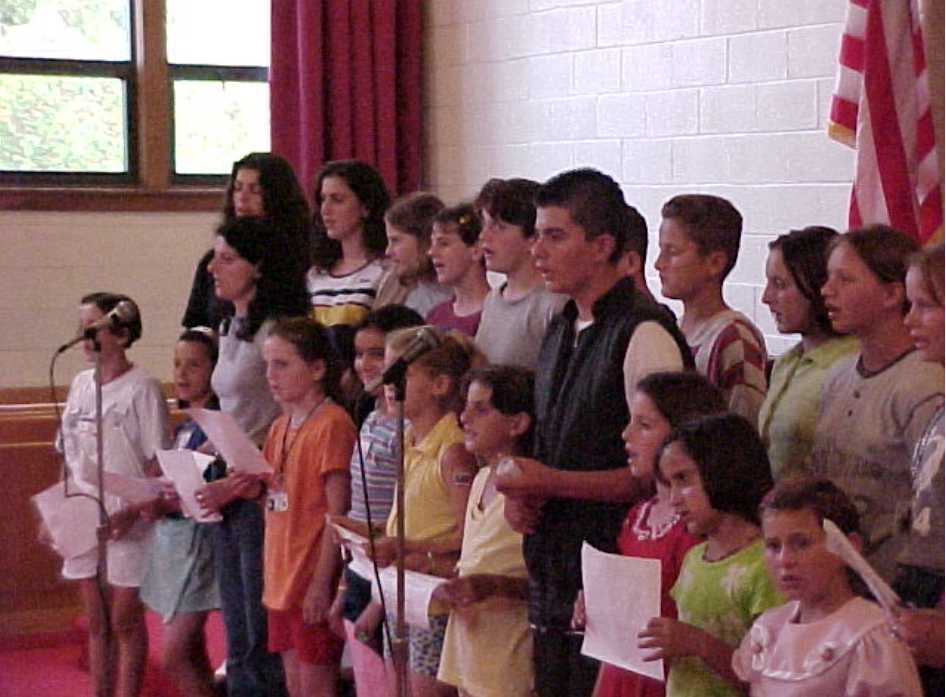 Refugee youth sing a song of gratitude as the camp prepares to close