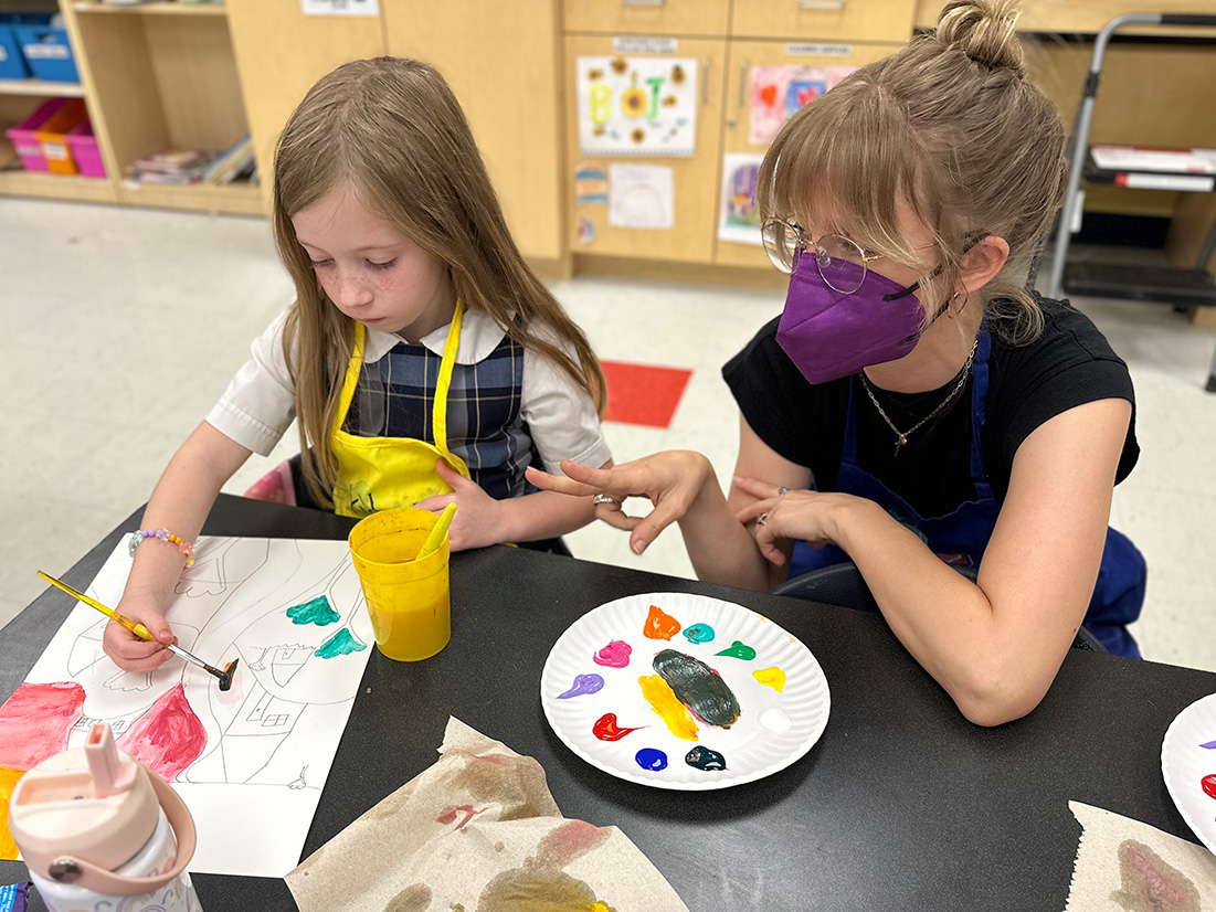 Lindsay B_Cornerstone VA a teacher helps a student who is painting